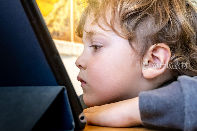 一个四岁的小男孩正在看他的电子平板电脑