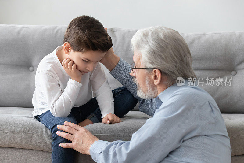 忧心忡忡的老爷爷安慰伤心的孙子，给予心理上的帮助