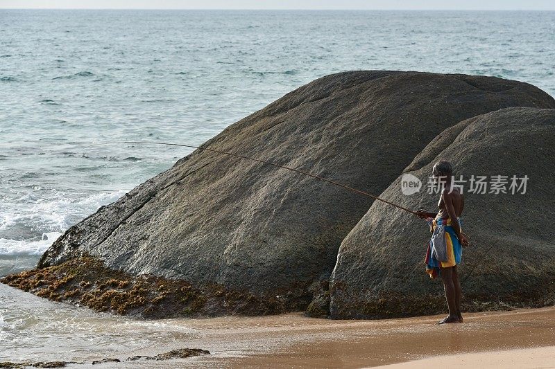 斯里兰卡安巴兰戈达附近的印度洋渔民拿着钓竿