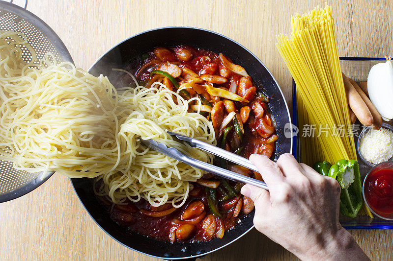 日式意面菜肴，意大利面(那不勒斯)的食谱和配料。在一个煎锅里，放上辣椒、香肠、洋葱和番茄酱，我奶奶把用钳子煮的意大利面放在锅里。