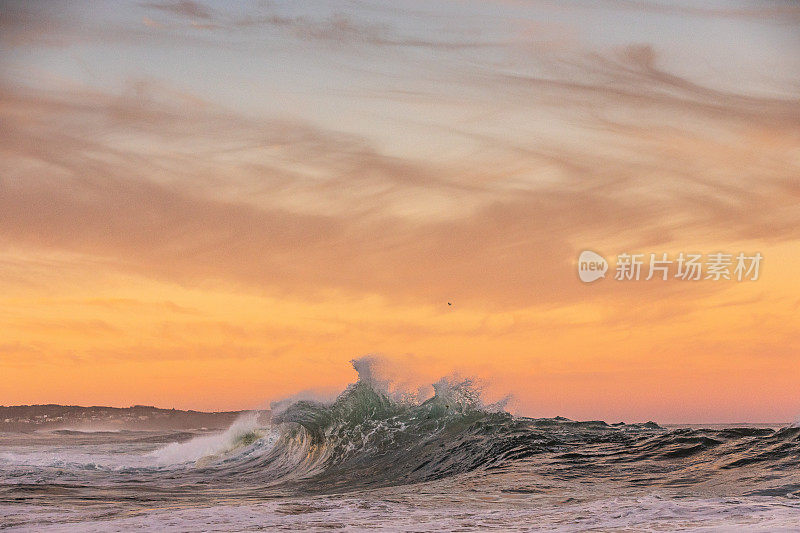 海浪与戏剧性的金色天空碰撞