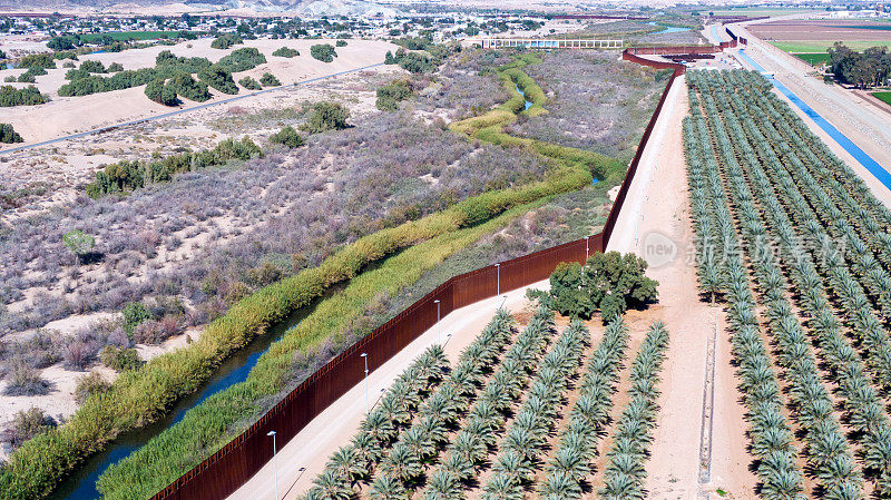 无人机拍摄的边境墙，科罗拉多引水大坝在亚利桑那州尤马和阿尔戈多内斯之间的国际屏障的河流排水，下加利福尼亚，墨西哥北部在一个阳光明媚的日子