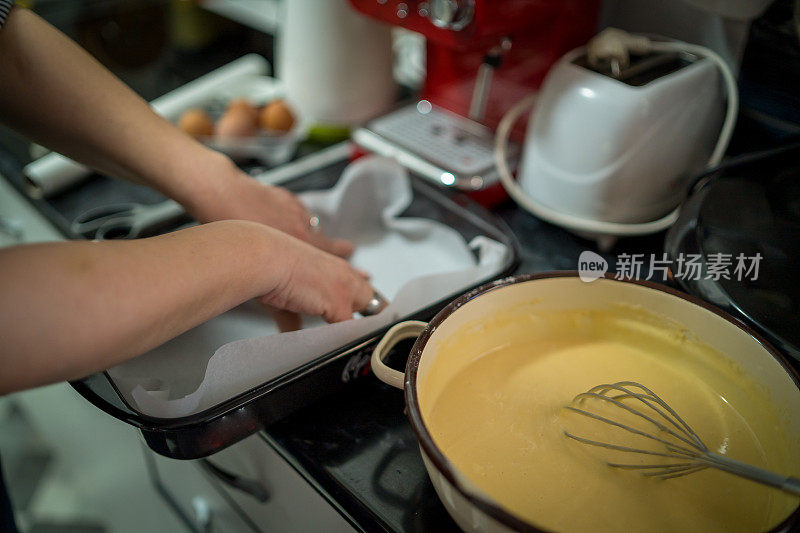 在家烘焙:一个穿围裙的女人准备烤盘来烘焙