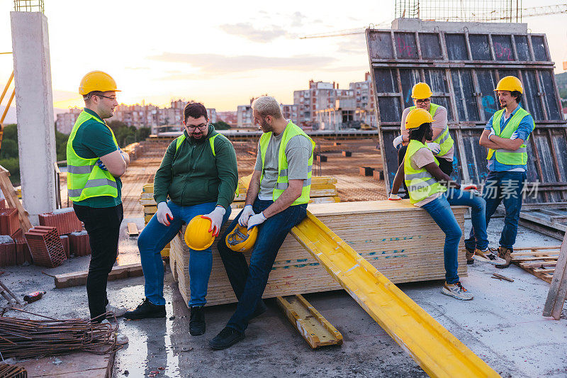 男建筑工人在建筑工地屋顶休息