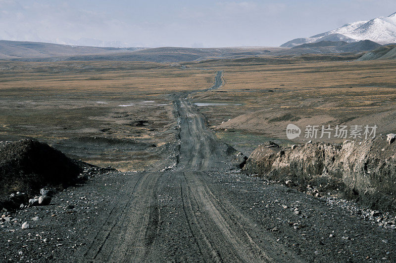 湿土路穿过高原天山高原走向山峰