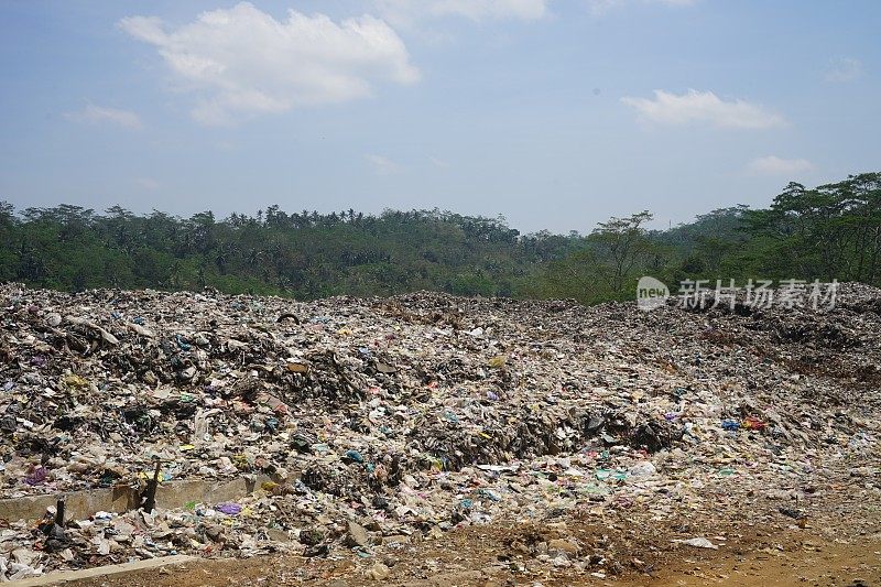 印度尼西亚，temanggong——2023年8月13日:成堆的垃圾被挖土机和拾荒者堆在一起