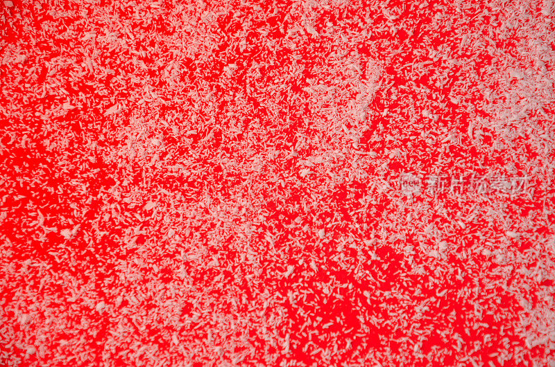 红色背景洒上椰子片，雪的概念