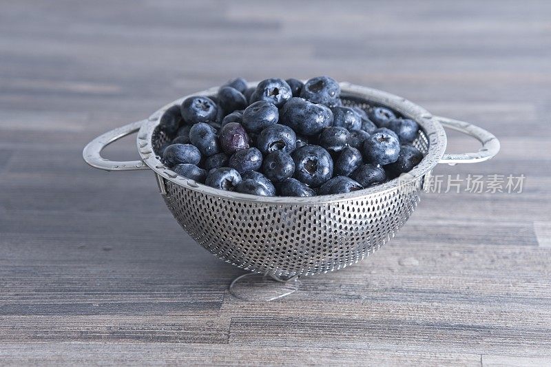 不锈钢滤锅里刚洗过的蓝莓特写