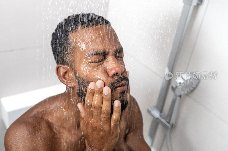 男子在淋浴时洗脸