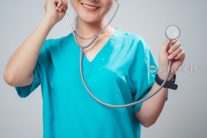 一个穿着医生制服的女人的特写镜头，医生快乐地微笑着，拿着听诊器，孤立在白色的背景上。