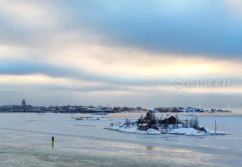 覆盖着冰的波罗的海，一个小岛和赫尔辛基在地平线上。