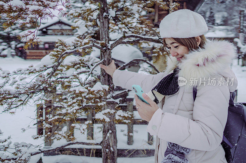 美丽的女游客享受他们的日本之旅在雪的冬天