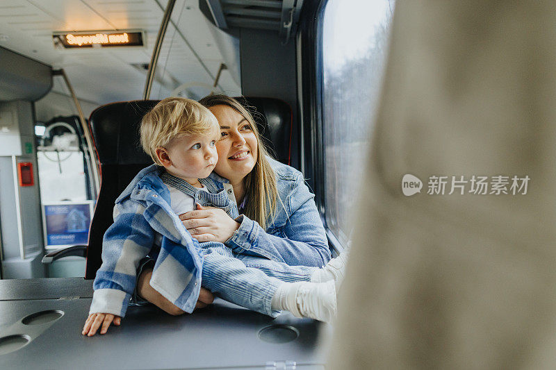 年轻的母亲带着她的男婴乘火车旅行
