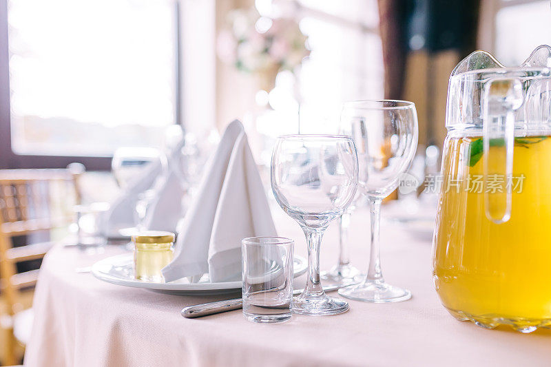 餐厅桌子上的玻璃杯和盘子。浪漫的豪华餐桌与空餐具