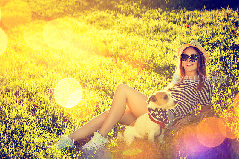 嬉皮士女孩和她的狗躺在草地上