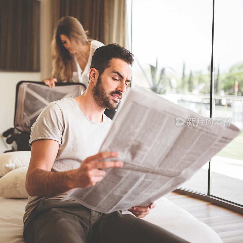 男人在卧室里看报纸