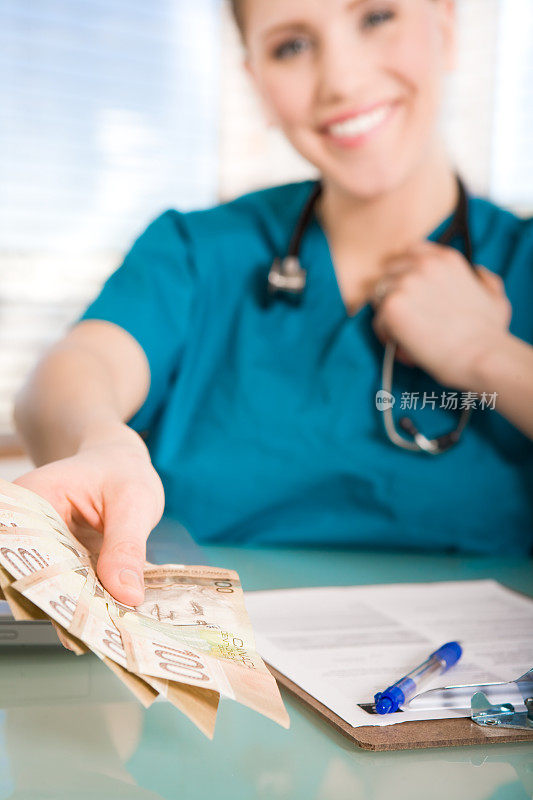 微笑的护士拿着加拿大的钱
