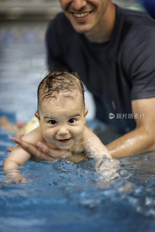 在游泳池里微笑的男婴