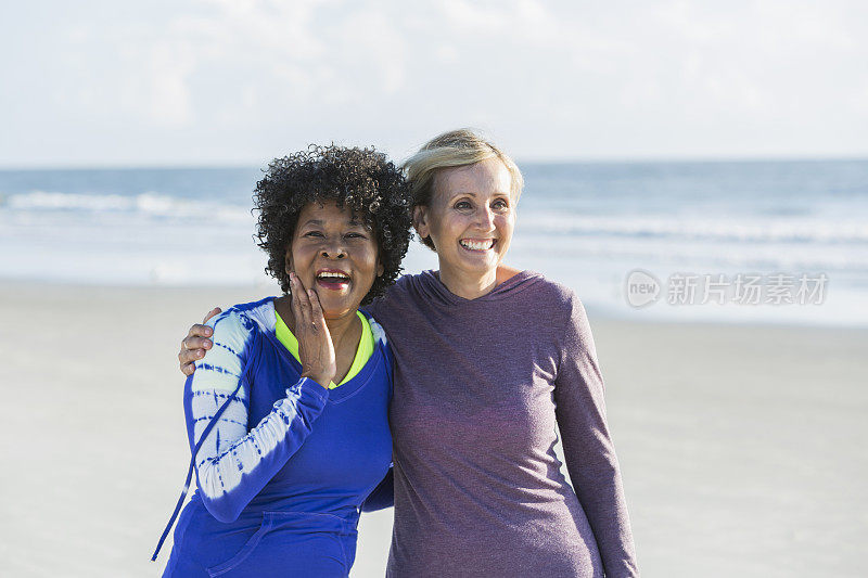 两个不同种族的成熟女人一起在海滩上散步