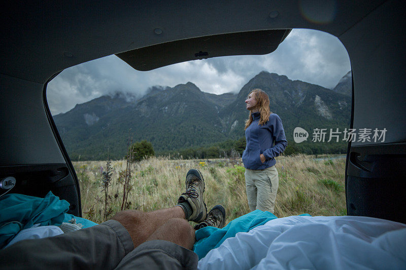 个人视角的男人躺在汽车的后备箱，山景