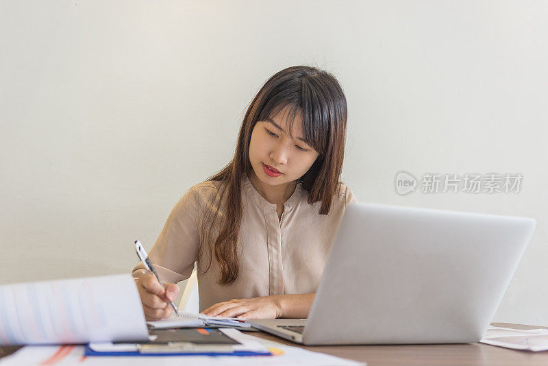 特写女商人在她的办公室手写笔记