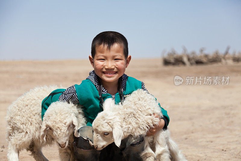 快乐的中国男孩和他的小羊在户外