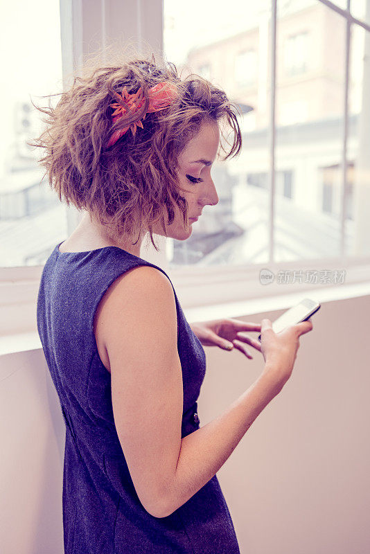 年轻时髦的女商人用手机发短信。