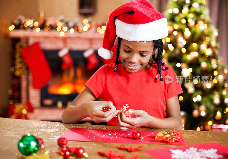 漂亮的女孩在做圣诞卡片。