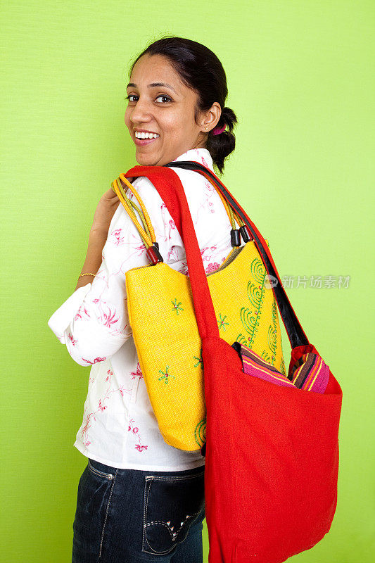 兴高采烈的印度女人拿着购物袋垂直生活方式拍摄