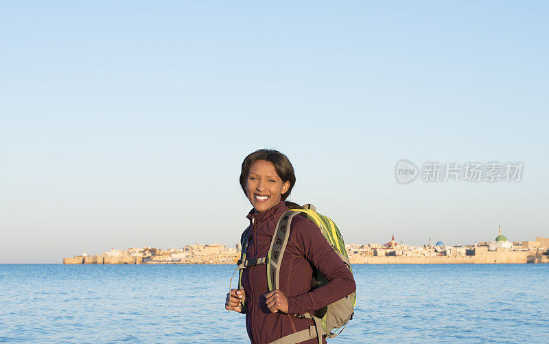 在阿克古城旅行的背包女。