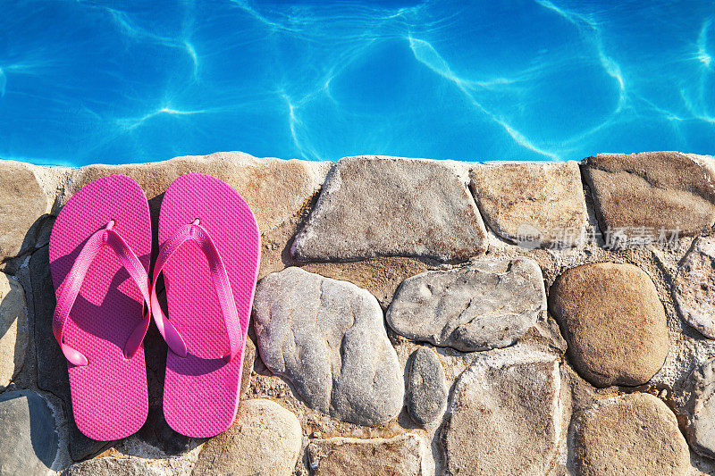 游泳池旁边的粉色拖鞋