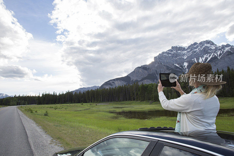 女人在山路上的阳光车顶拍照