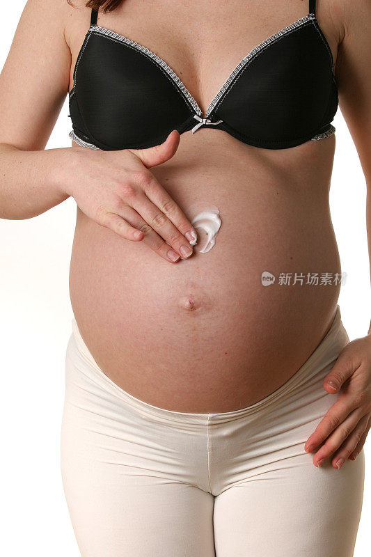 在孕妇腹部涂抹保湿霜
