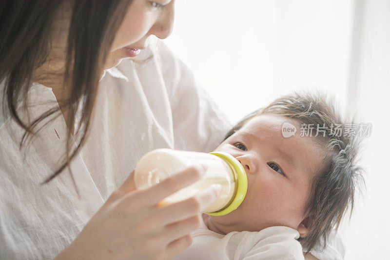 年轻的母亲在家里爱着她的宝贝女儿