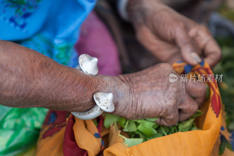 印度老年妇女在集市上卖蔬菜