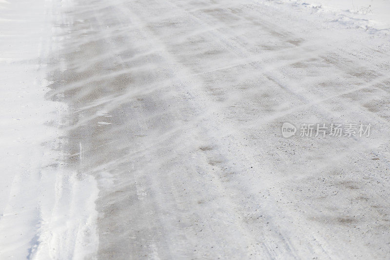 大风把雪吹在柏油路上