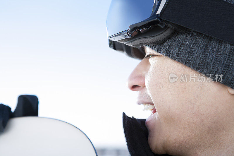 快乐的男性滑雪板对蓝色的天空