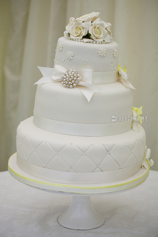 婚礼蛋糕白色与黄色装饰，玫瑰和蝴蝶结