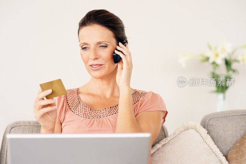 成熟女性在网上购物，使用信用卡和手机
