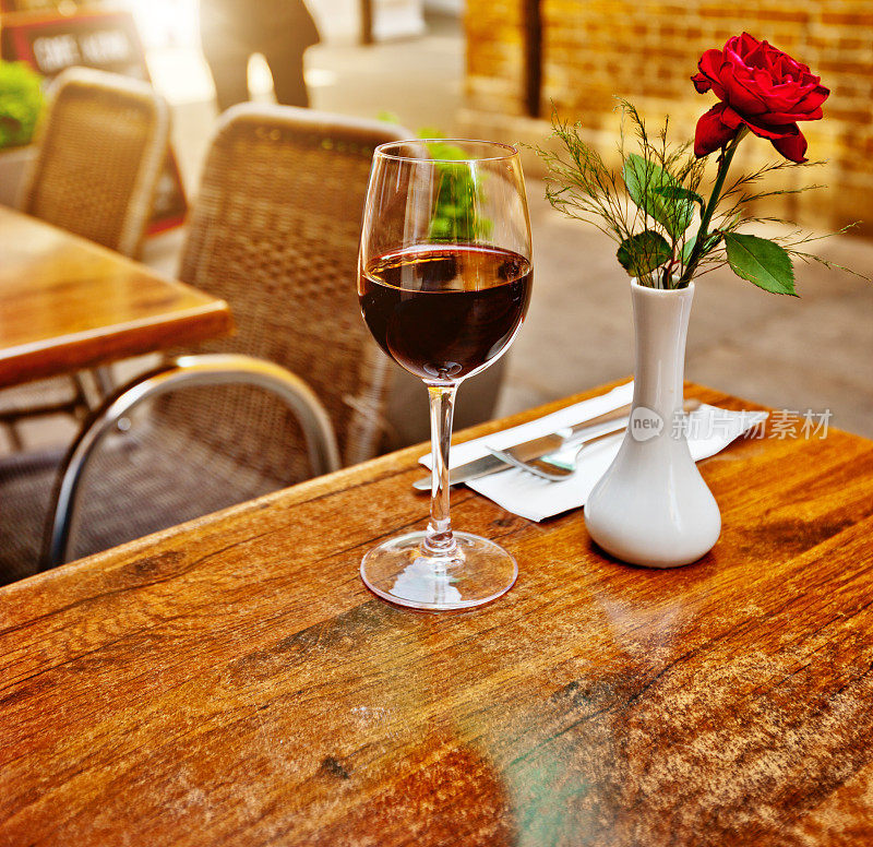 户外餐厅桌上的红酒和玫瑰