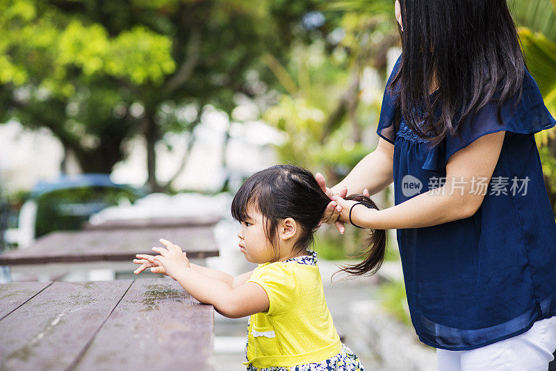 母亲给女儿扎头发