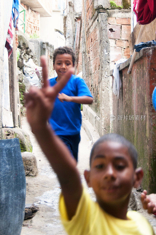 男孩们跑过圣玛尔塔贫民窟的小街道