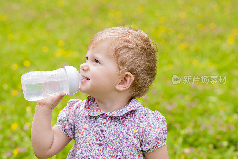 可爱的宝宝在外面喝瓶子里的水