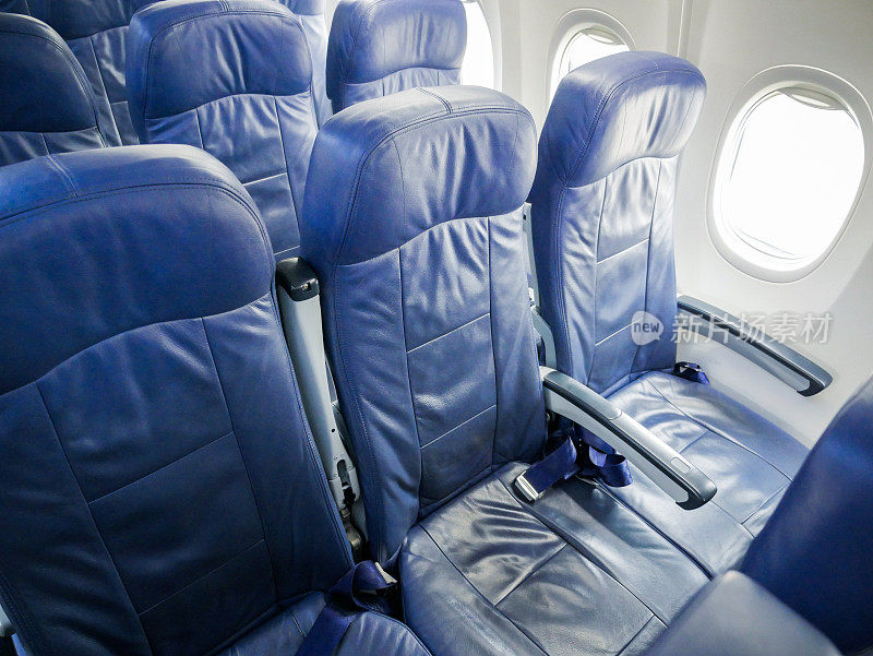 有蓝色乘客座位的商用飞机客舱。