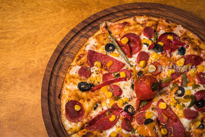 从上面看，木头桌上放着美味的意大利披萨