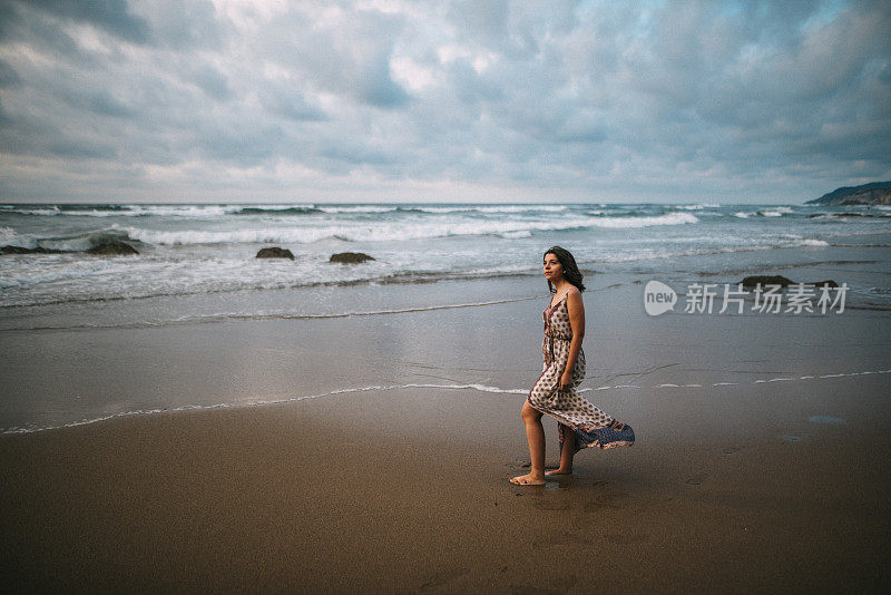 在海滩上穿着衣服的年轻女子