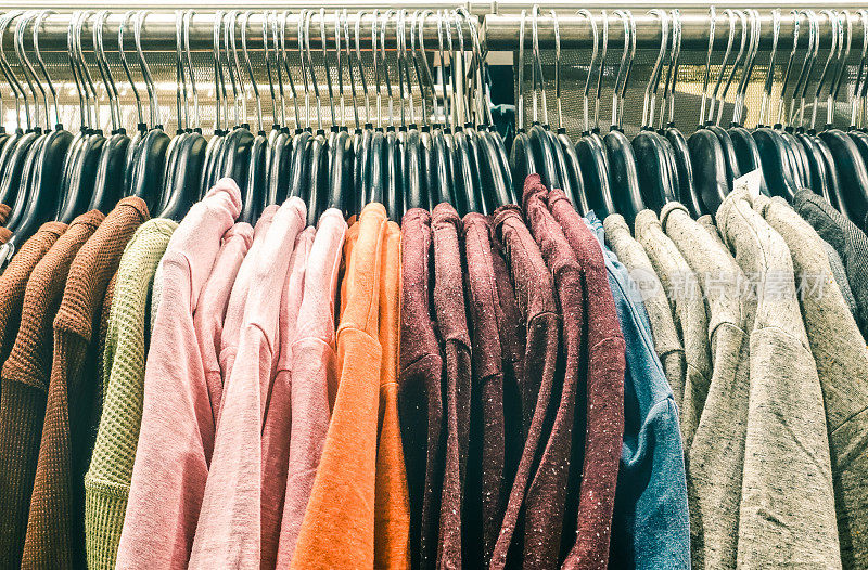 二手套衫衣服挂在跳蚤市场商店的旧货店-潮人衣柜销售概念和另类复古moda时尚造型-软对比饱和怀旧过滤看