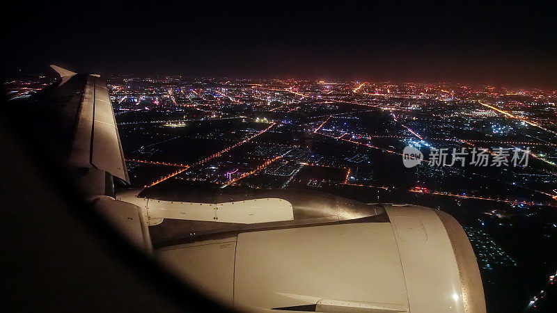 飞机机翼在城市上空的夜晚