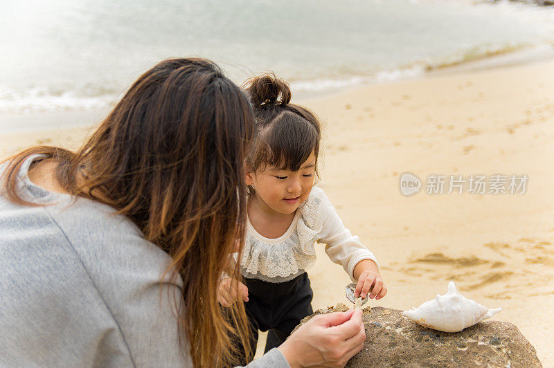 妈妈和小女孩在海滩上玩