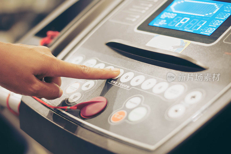 在健身房跑步机上按下按钮，手指闭合
